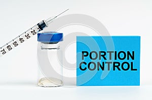 On the table is a syringe, an injection and a blue sign with the inscription - Portion Control