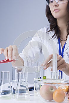 Medicine Concepts and Ideas. Female Laboratory Staff Working with Flasks and Fruits Specimens in Laboratory