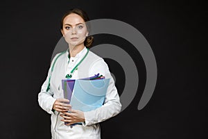Medicine Concepts. Portrait of Professional Female GP Doctor Posing in Doctor`s Smock and Endoscope Against Black