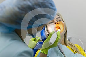 Medicine, dentistry and healthcare concept, dentist using dental curing UV lamp