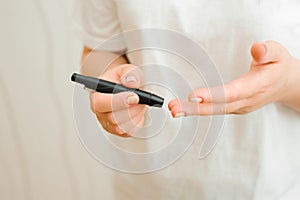 Medicine, Diabetes, Glycemia, Health care and people concept - close up of female finger with blood drop and test stripe