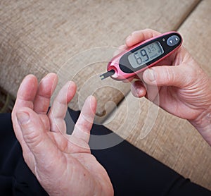 Medicine, diabetes, glycemia, health care and people concept - close up of woman checking blood sugar level by photo