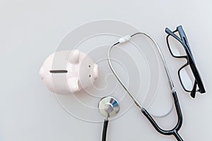 Medicine doctor equipment stethoscope or phonendoscope piggy bank glasses isolated on white background