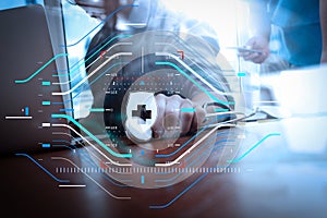 Medicine doctor hand working with modern computer and smart phone on wooden desk as medical concept