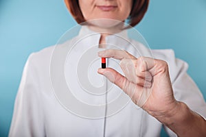 Medicine doctor holding a color capsule pill in hand