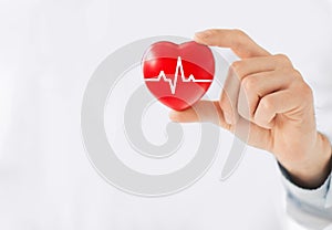 Medicine doctor holding red heart shape in hand with medical icon network connection modern virtual screen interface, service mind