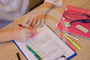 Medicine doctor`s working table. Doctor sits in a medical office in the clinic and writes medical history