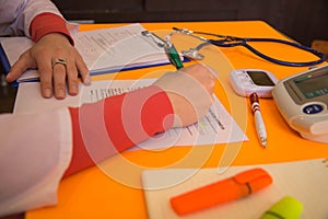 Medicine doctor`s working table. Medical concept. Doctor sits in a medical office in the clinic and writes medical history