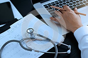 Medicine doctor. Stethoscope with heartbeat report, analyzing checkup on laptop