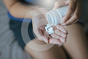 Medicine drug on hand,Woman hand with pills on spilling pills out of bottle