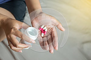 Medicine drug on hand,Woman hand with pills on spilling pills out of bottle