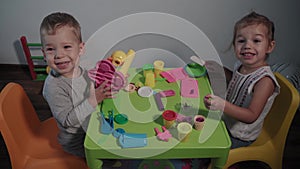 Medicine, family, game, childhood, art concepts - two happy young children play with colored plasticine ice cream