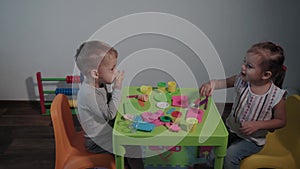 Medicine, family, game, childhood, art concepts - two happy young children play with colored plasticine ice cream