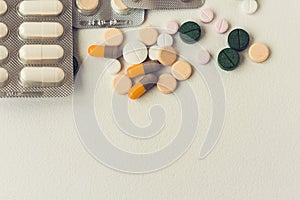 Medicine green, pink and yellow pills or capsules on white background with copy space. Drug prescription for treatment medication