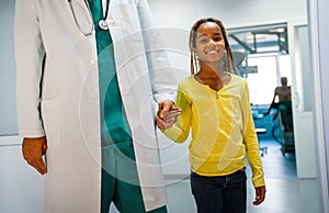 Medicine, healtcare, pediatry and people concept. Doctor or pediatrician holding a happy kid hand