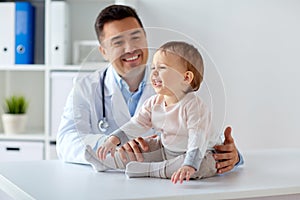 Happy doctor or pediatrician with baby at clinic photo