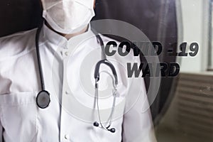 Medicine and health care concept. Close-up of man doctor in hospital. Doctor wearing protective mask checking and take