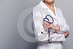 Medicine and health care concept. Physician or doctor hand with stethoscope on blue background