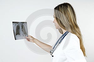 Medicine and health concept. A young woman doctor examines an x-ray picture of human chest