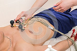 Medicine, health and heart check-up concept - Male patient having ECG electrocardiogram in hospital