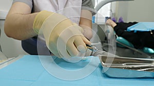 Medicine and healthcare concept. Dentist prepares syringe for injection of anesthesia with blurred patient on background