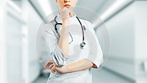 Medicine And Healthcare Concept. Female Medicine Doctor With Stethoscope Standing With Arms Crossed And Thinking About Diagnosis