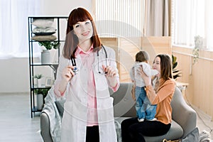Medicine, healthcare, pediatry and people concept - woman doctor in white coat and with stethoscope visiting patient at