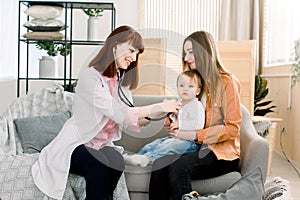 Medicine, healthcare, pediatry and people concept - Young woman Pediatrician checks breath stethoscope a little girl in