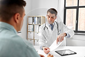 Doctor giving prescription to patient at hospital