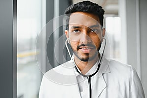 medicine, healthcare and people concept - happy male doctor with stethoscope and clipboard at clinic