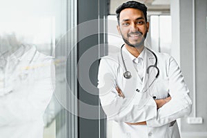 medicine, healthcare and people concept - happy male doctor with stethoscope and clipboard at clinic