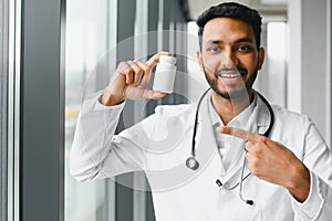 medicine, healthcare and people concept - happy male doctor with stethoscope and clipboard at clinic