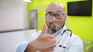 Medicine, healthcare and people concept - portrait of happy smiling young male doctor showing thumbs up