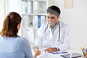 Doctor giving prescription to patient at hospital