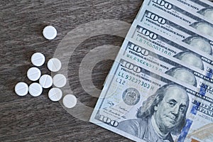 Medicine pill on 100 dollar banknote background.Healthcare insurance and medical treatment cost concept