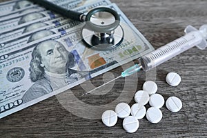 Medicine pill and Medical stethoscope on 100 dollar banknote background.Healthcare insurance and medical treatment cost concept