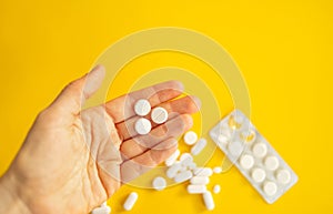 medicine pills, antibiotic tablets on a yellow background, treatment of colds and illnesses