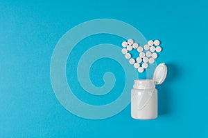Medicine pills heart shaped on blue background. Heart protection. Drug prescription for treatment medication. Pharmaceutical medic