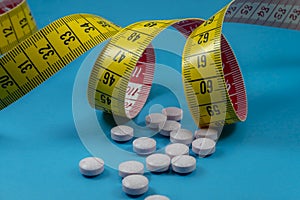 Medicine pills and measuring tape blue background