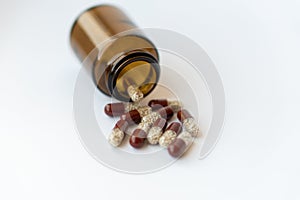 Medicine and pills. Medicines on a white background close-up. Brown glass bucket with capsules inside on a white