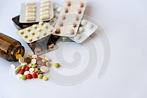 Medicine and pills. Multi-colored medicines on a white background close-up. Brown glass bucket and tablets with pills on