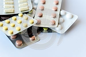 Medicine and pills. Multi-colored medicines on a white background close-up. Plate with multi-colored tablets on a white