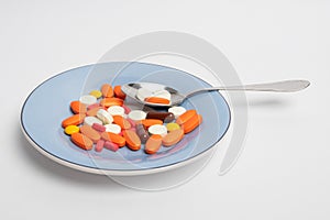 Medicine pills on a plate. Saucer with orange vitamin tablets