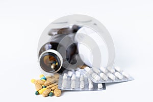 Medicine pills ,tablets and capsules spilling out of pill bottle on white background