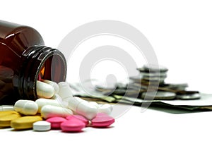 Medicine pills, vitamins and bottle on blurred money coin and white background with copy space