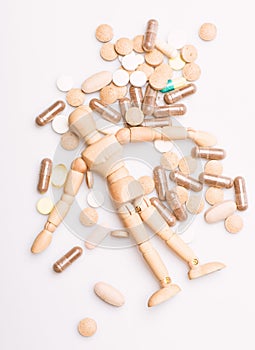 Medicine prescription. Wooden human dummy lay on pile of pills and tablets. Take medicine concept. Health and treatment