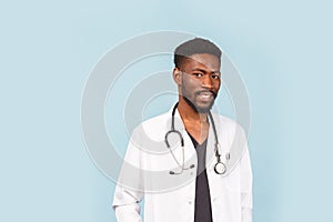 Medicine, profession and healthcare concept. African american male doctor with stethoscope in white coat on blue background