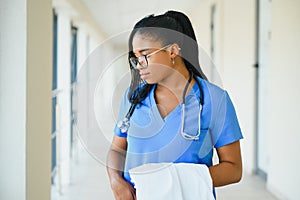 Medicine, profession and healthcare concept - happy smiling african american female doctor with stethoscope over hospital