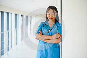 Medicine, profession and healthcare concept - happy smiling african american female doctor with stethoscope over hospital