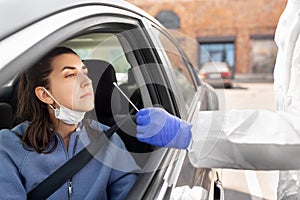 Healthcare worker making coronavirus test at car